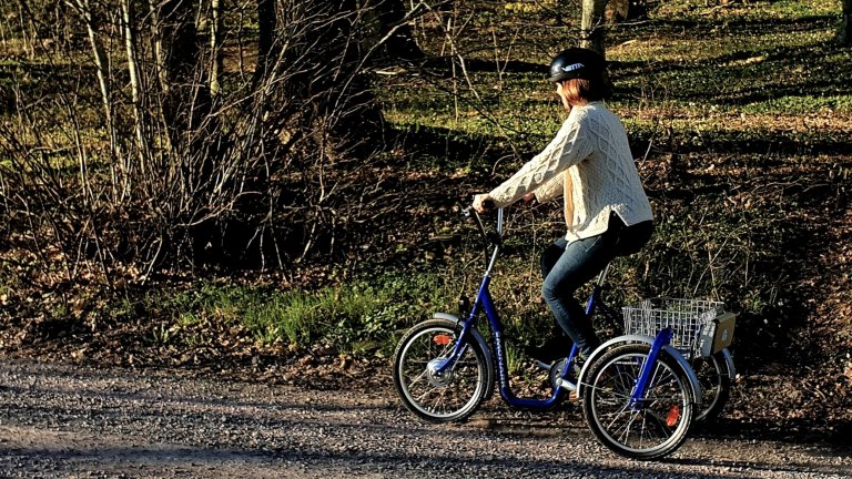 En person cyklar på en eldriven trehjuling