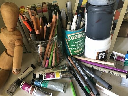 Burkar med pennor, akrylfärg, kritor och färgpennor