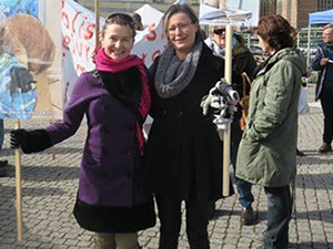 Två leende kvinnor som håller upp skyltar