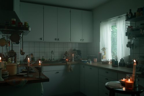 En mörkt kök där strömmen gått. Tända ljus står placerade runt om i köket. 