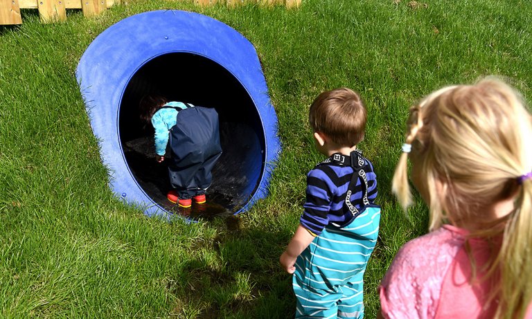 Barn kryper i blå tunnel