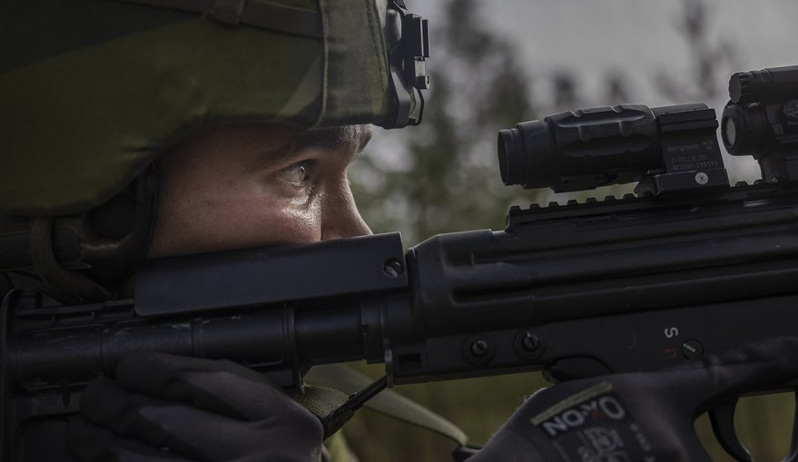 En militär som håller ett skjutvapen.